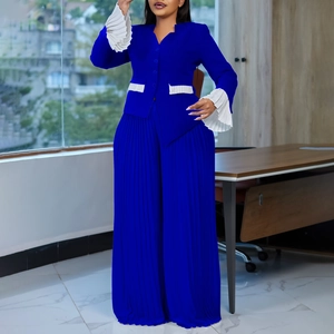 Close-up of pleated wide-leg trousers and sleeve ruffles in royal blue suit fabric