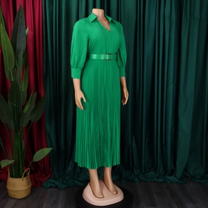 Detail of green pleated dress with V-neckline, metal buckle belt and waistline fold design