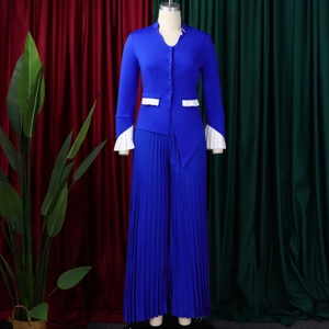 Detailed close-up of bell sleeves and pleated white trim on a blue two-piece pant set