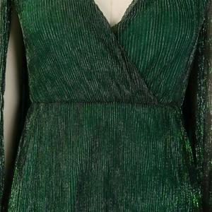 Close-up of pleated dark green metallic fabric with shimmering luxury texture