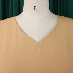 Close-up of V-neckline detail on khaki elegant A-line dress with woven fabric texture