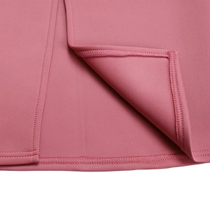 Detail shot of solid pink dress showing fine stitching and ruffle edge texture