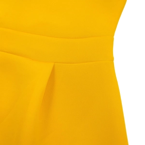 Macro shot of ginger yellow cocktail dress waistline with fine pleated craftsmanship