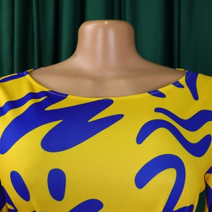 Detail of round neckline with vibrant African blue fluid pattern on yellow fabric