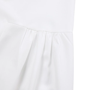 Detailed macro view of the gathered waist and fine stitching on the white cotton dress