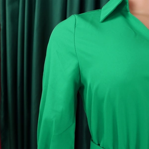 Detail shot of a vibrant green V-neck dress collar with premium stitching and fine fabric