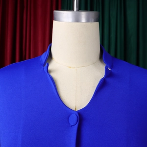 Detail of royal blue wide-leg suit top featuring elegant stand-up collar and fabric button