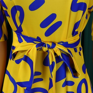 Detailed view of yellow African print dress featuring a tied bow at the waistline