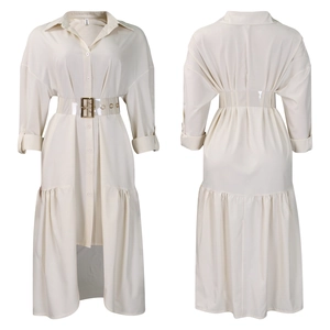 Detail of ivory long sleeve shirt dress featuring pleated layered hem and matching belt