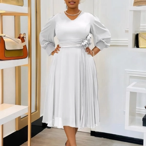 Close-up of white V-neck dress featuring lantern sleeves and floral waist detail