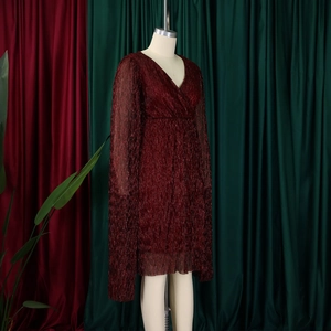 Detail of red metallic pleated dress featuring V-neck and elegant cape sleeves