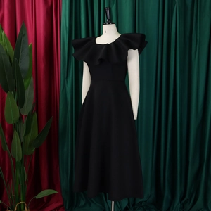 Détail de la robe noire élégante montrant le décolleté à volants et la coupe ajustée