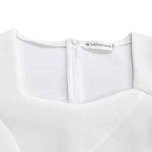 Detail of square neckline and back invisible zipper on white ruffle dress with brand label