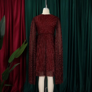 Detailed texture of burgundy pleated fabric with cape sleeves on an elegant evening gown