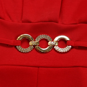 Close-up of gold metal buckles with rhinestones on red high-waist jumpsuit fabric