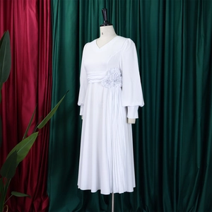 Detail of white V-neck dress featuring 3D floral accents and elegant pleated skirt design