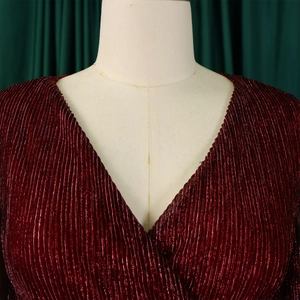 Macro shot of V-neckline featuring metallic pleated fabric in dark wine red color