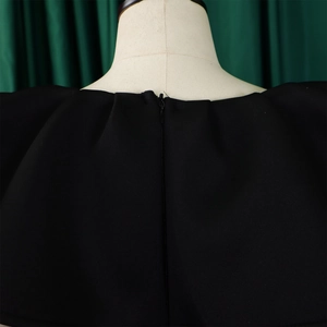 Détail de la fermeture éclair invisible et des volants sur cette robe de soirée noire