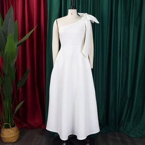 Detail of the oversized white shoulder bow on an elegant one-shoulder formal dress