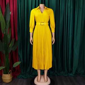 Detailed view of yellow pleated dress featuring vertical pleats and a matching waist belt