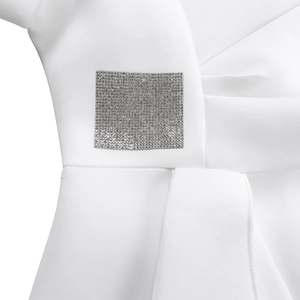 Detail view of elegant white dress showing square rhinestone embellishment on the fabric