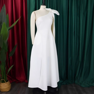 Detail of elegant white one-shoulder evening gown with oversized shoulder bow and A-line drape