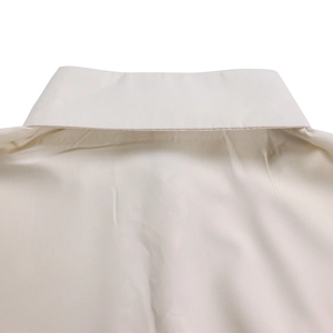 Detailed view of shirt collar and back yoke stitching on apricot cotton dress