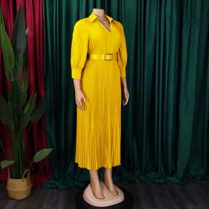 Detail of yellow pleated dress featuring elegant lapel V-neck and matching waist belt