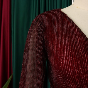 Close-up of elegant burgundy V-neck dress featuring metallic pleated fabric texture