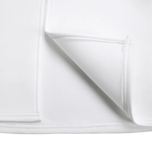Detailed close-up of the elegant white ruffle hem and precision stitching on the dress