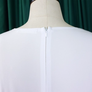 Detail view of a hidden back zipper on a solid white dress with smooth woven texture