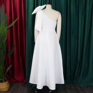 Detailed back view of white one-shoulder gown featuring a large bow and A-line skirt