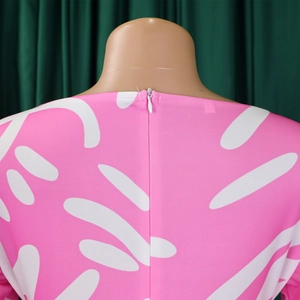 Detail of the back invisible zipper and abstract white leaf print on a pink dress