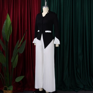 Close-up of elegant flared sleeves with white ruffles and pleats on a stylish woman suit