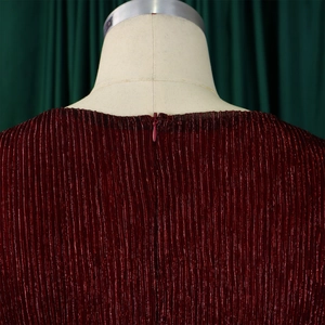 Detail of burgundy pleated dress featuring an invisible back zipper and metallic luster