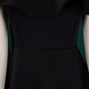 Détail de l'encolure à volants et de la taille ajustée sur une robe de soirée noire