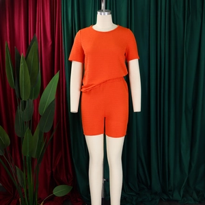 Détail d'un ensemble deux pièces orange vif avec tissu texturé sur un mannequin femme