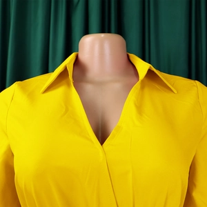 Detailed view of deep V-neckline and collar on a bright yellow long sleeve dress