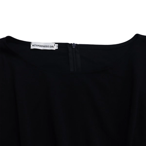 Detail of the high-waist jumpsuit neckline with a brand logo tag and metal zipper closure