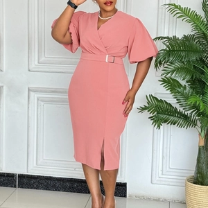 Detail of coral pink V-neck dress featuring puff sleeves and an elegant waist belt