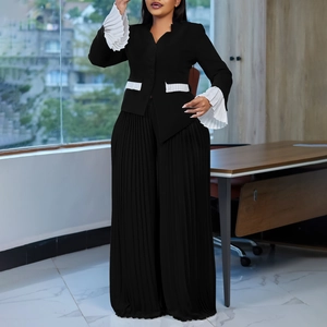 Detail of white accordion pleat accents on black flared sleeves and blazer pockets