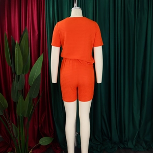 Texture détaillée du haut orange à manches courtes et du short assorti sur un mannequin