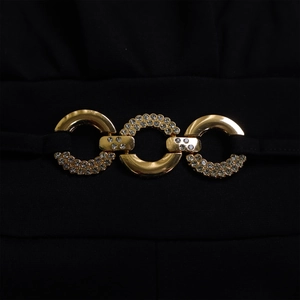 Detailed macro view of gold-tone interlocking rings with sparkling rhinestones on fabric