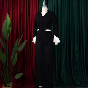 Close-up of contrast white pleated cuffs and pocket trim on black flare sleeve top