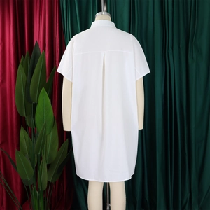 Detail view of the inverted pleat on the back of a white short-sleeve shirt dress