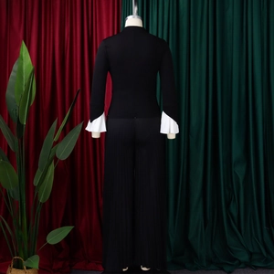 Detail of flared cuffs with white ruffle layers on a black long sleeve top set