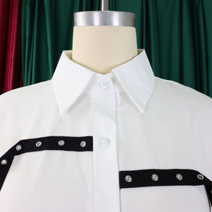 Detail of white shirt showing silver metal eyelets on black decorative webbing trim