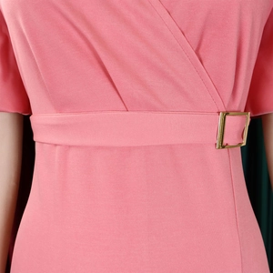 Detail of pink V-neck dress featuring a wrap waist and gold square buckle belt