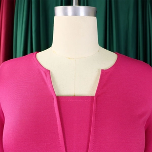 Détail de la robe en maille texturée rose avec encolure superposée et design élégant