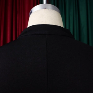 Detail shot of the back collar and shoulder of this black bell-sleeve top with fine stitching